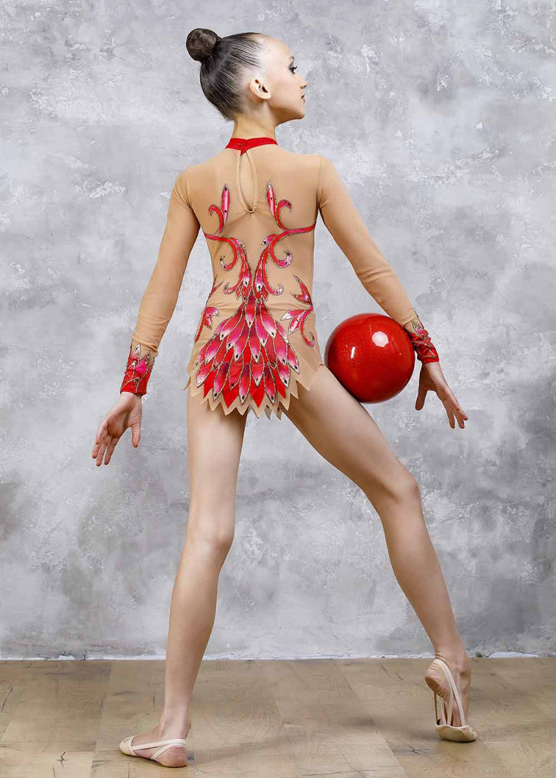 Rhythmic gymnast in a red and beige leotard with a ball against