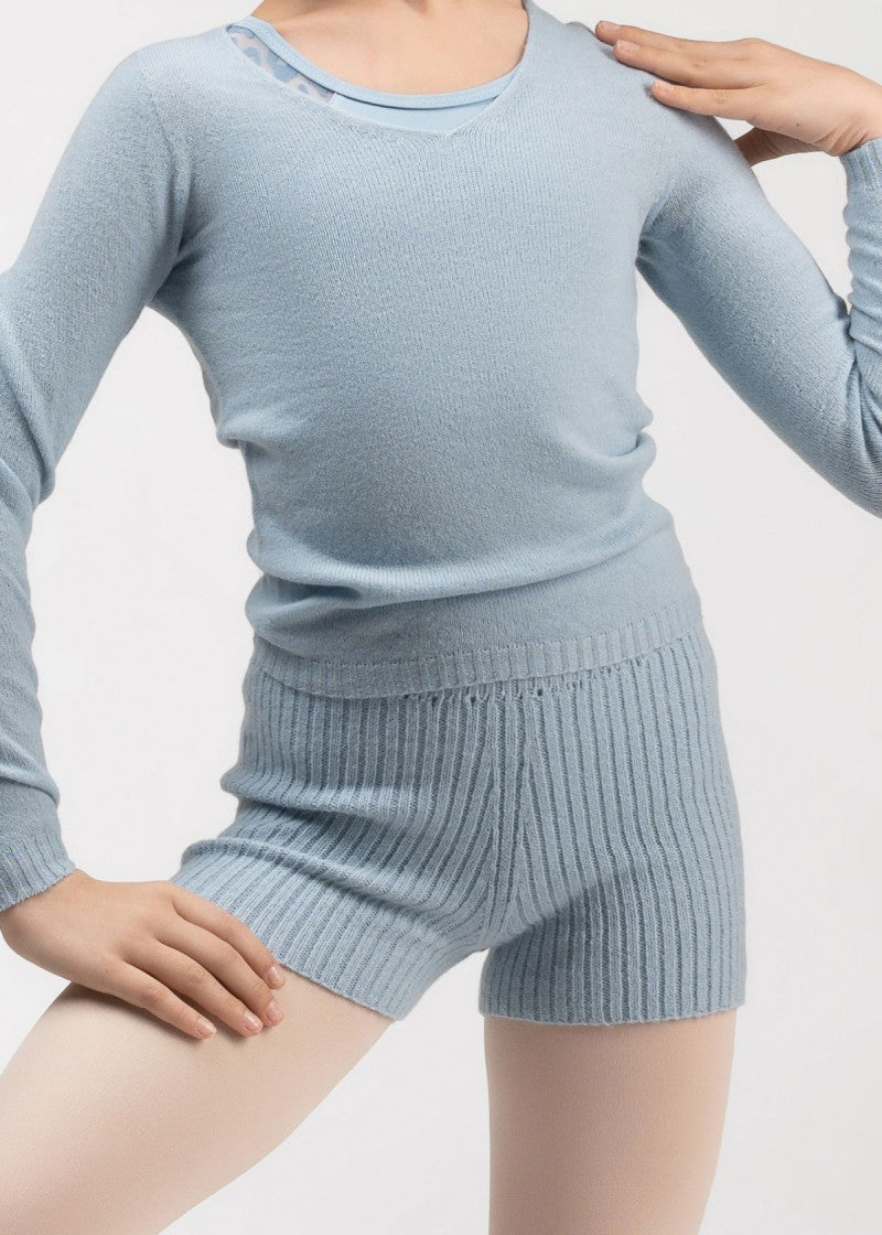 A child wearing a light blue ribbed knit long-sleeve top and matching ribbed knit shorts 